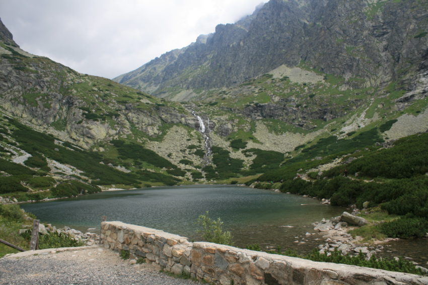 Water cascades down a mountain into a lake.