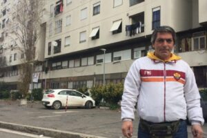 De Santis in front of his building where his brother threw himself off of and where Carlo still lives today.