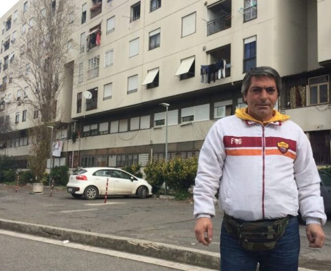 De Santis in front of his building where his brother threw himself off of and where Carlo still lives today.