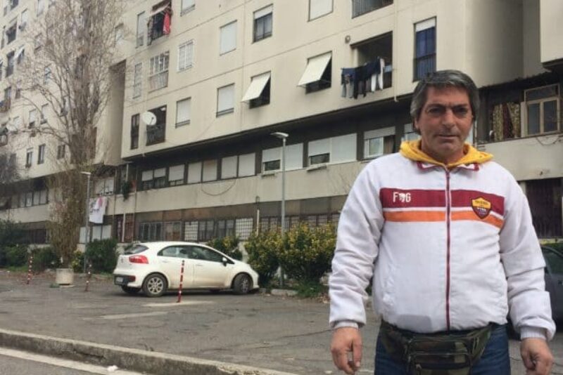 De Santis in front of his building where his brother threw himself off of and where Carlo still lives today.