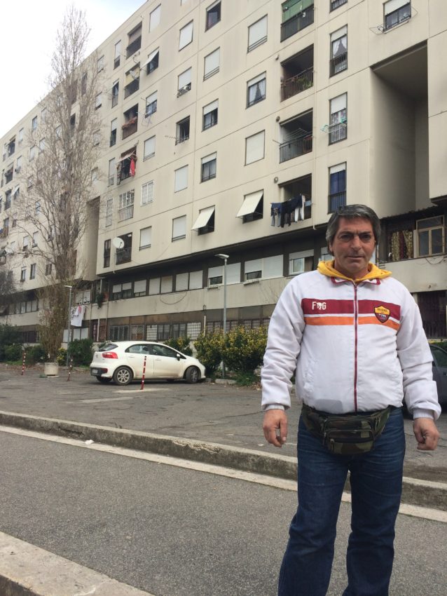 De Santis in front of his building where his brother threw himself off of and where Carlo still lives today.