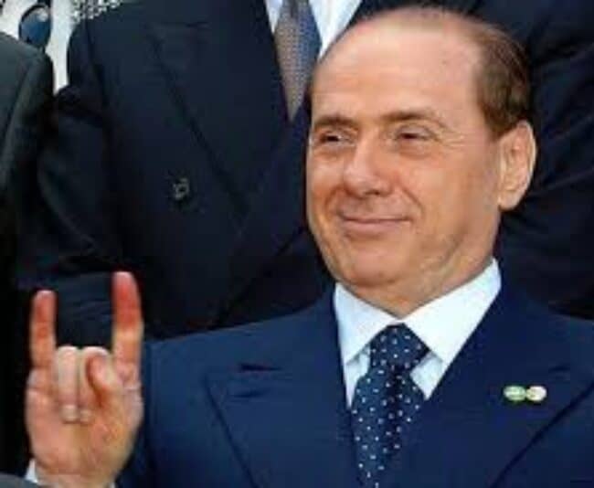 Silvio Berlusconi giving the Italian gesture for cheating.