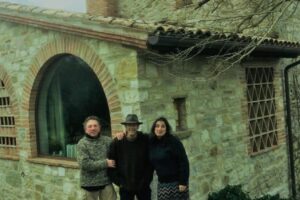 Fabrizio Bizzarri, Ev Thomas and Claudia Rizza stand in front of Thomas' and Rizza's 800-year-old house in Umbria.