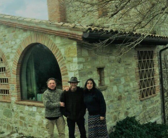 Fabrizio Bizzarri, Ev Thomas and Claudia Rizza stand in front of Thomas' and Rizza's 800-year-old house in Umbria.