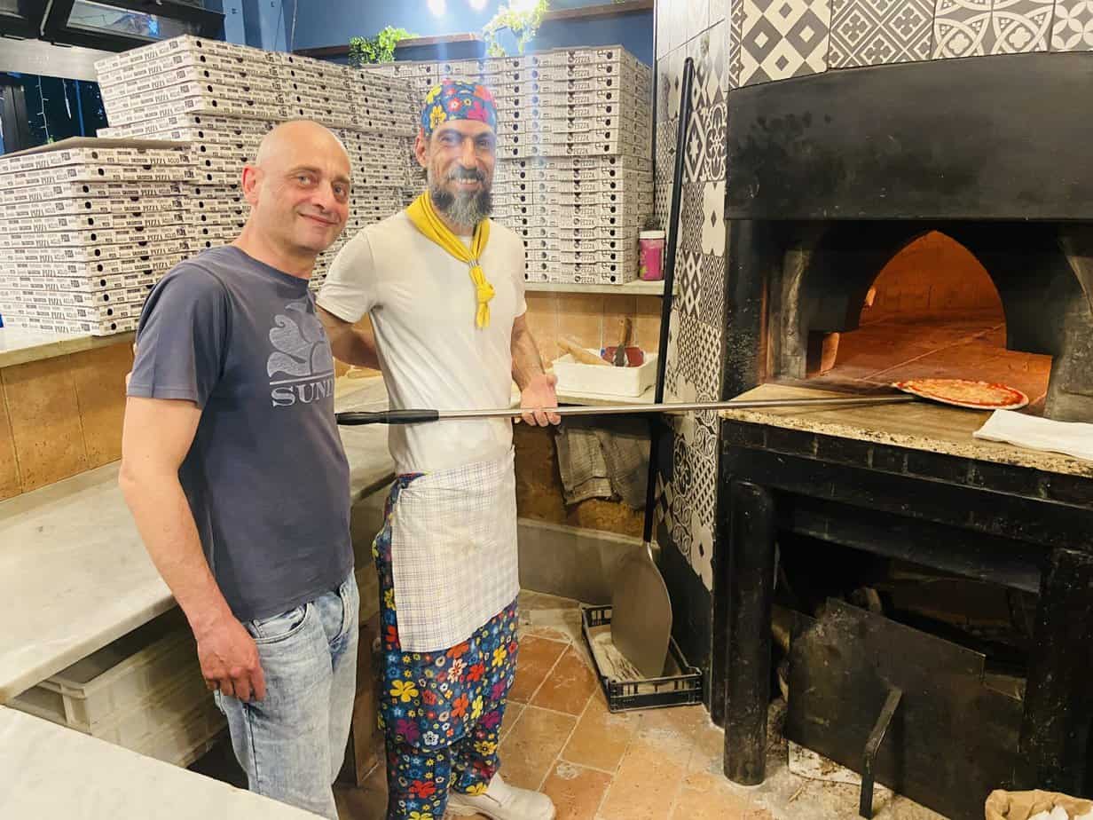 Owner Luca Manetti (left) and chef Dino stand in front of Pepito's, one of the city's typical Roman-style pizzerias.